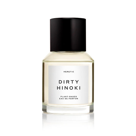 Glass bottle of "dirty hinoki" plant-based eau de parfum against a white background.
